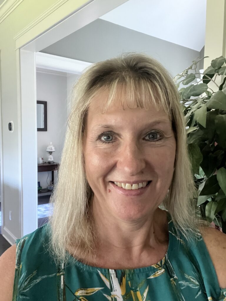 Dawn smiling in a teal floral top